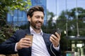 Confident businessman with coffee and smartphone enjoying break outside modern office building Royalty Free Stock Photo