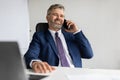 Successful Mature Businessman In Suit Talking On Mobile Phone At Office Royalty Free Stock Photo