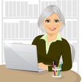 Successful mature businesswoman working typing on her laptop at office Royalty Free Stock Photo