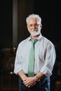 Successful, mature, university rector standing proudly and posing for the camera.