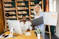 Successful multiracial business partners working on new project together in modern office, smiling. Happy stylish Royalty Free Stock Photo