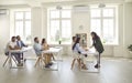 Successful people who are adult students and sitting at desks in a modern bright classroom. Royalty Free Stock Photo