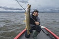 Successful pike fishing. Happy fisherman hold huge muskie fish Royalty Free Stock Photo