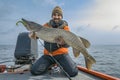 Successful pike fishing. Happy fisherman hold huge muskie fish