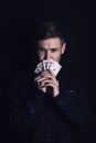 Successful poker player holds up a winning royal flush combination. Lucky gambler with playing cards on a dark background. Casino Royalty Free Stock Photo