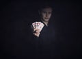 Successful poker player holds up a winning royal flush combination. Lucky gambler with playing cards on a dark background. Casino Royalty Free Stock Photo