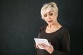 A successful positive modern elderly woman holds a tablet in her hands and uses it. The older generation and modern Royalty Free Stock Photo