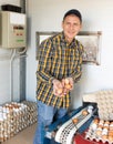 Successful poultry farm owner with chicken eggs near conveyor belt Royalty Free Stock Photo