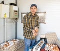 Successful poultry farm owner with chicken eggs near conveyor belt Royalty Free Stock Photo