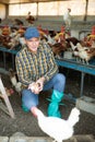 Successful poultry farm owner standing with eggs in hands in henhouse Royalty Free Stock Photo