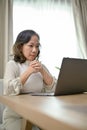 Successful Asian-aged businesswoman concentrating working, using laptop in her living room Royalty Free Stock Photo