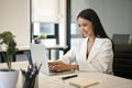 Successful Asian businesswoman typing on laptop keyboard, using her laptop Royalty Free Stock Photo