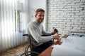 Successful project. Portrait of young positive male architect in a wheelchair looking at camera and smiling while Royalty Free Stock Photo