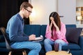 Successful psychotherapy. Woman having session with psychologist, sitting on couch at clinic. The woman is very upset, the