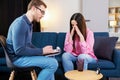 Successful psychotherapy. Woman having session with psychologist, sitting on couch at clinic. The woman is very upset, the