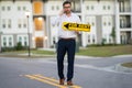 Successful real estate agent in a suit holding for rent sign near new apartment. Real estate agent with home loan Royalty Free Stock Photo