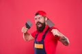 Successful renovation. Bearded man worker with plastering tools. Plasterer hipster builder in cap red background