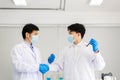 Successful and research working scientists man shake hands together in laboratory