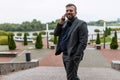 successful satisfied businessman speaks with a smile on a mobile phone well in a business suit on the background of a Royalty Free Stock Photo