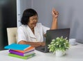 Successful senior woman working on laptop with arms raised Royalty Free Stock Photo