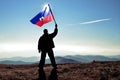 Successful silhouette man winner waving Haiti flag on top of the mountain