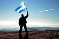 Successful silhouette man winner waving Honduras flag on top of the mountain