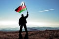 Successful silhouette man winner waving Malawi flag on top of the mountain