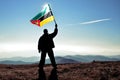 Successful silhouette man winner waving Mozambique flag on top of the mountain Royalty Free Stock Photo