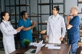 Successful skilled young doctor getting team applause in light office room at modern hospital. Royalty Free Stock Photo