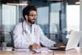 Successful smiling doctor working inside modern clinic office, hindu man in white medical coat working in medical office Royalty Free Stock Photo