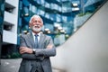 Successful smiling professional standing with his arms crossed outside modern business office building Royalty Free Stock Photo