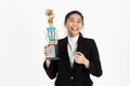 Successful smiling young Asian business woman celebrating with trophy award over white isolated background. Success achievement in Royalty Free Stock Photo