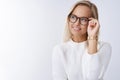 Successful stylish and elegant young lady in glasses and sweater looking delighted with happy pleased smile at upper