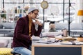 Successful stylish manager thoughtfully considering project at office desk