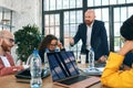 Successful team leader and business owner leading informal in-house business meeting. Businessman working on laptop in Royalty Free Stock Photo