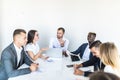 Successful team leader and business owner leading informal in-house business meeting. Businessman working on laptop in foreground Royalty Free Stock Photo