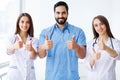 Successful team of medical doctors are looking at camera and smiling while standing in hospital Royalty Free Stock Photo