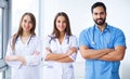 Successful team of medical doctors are looking at camera and smiling while standing in hospital Royalty Free Stock Photo