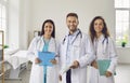 Successful team of medical doctors are looking at camera and smiling while standing in hospital. Royalty Free Stock Photo