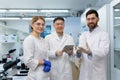 Successful team of scientists, three persons man and woman smiling and looking at the camera, portrait of a group of Royalty Free Stock Photo