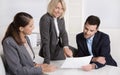 Successful teamwork: career businesswoman and businessman sitting around a table talking together in a meeting. Royalty Free Stock Photo