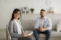 Successful treatment concept. Confident arab female psychologist and young man smiling after effective therapy Royalty Free Stock Photo