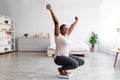 Successful weigt loss. Overjoyed plump black woman sitting on scales, raising hands up, achieving slimming goal Royalty Free Stock Photo