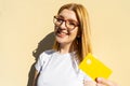 Successful White teen with glasses smile presenting with positivity the approved debit bank card. Blonde joyful student holding