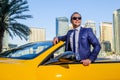 Successful yang businessman in yellow cabrio car.