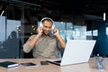 Successful young african american businessman relaxing in office, man in shirt and headphones listening to music online Royalty Free Stock Photo