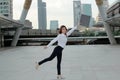 Successful young Asian business woman raising her arms with document folder at urban building background. Royalty Free Stock Photo