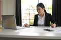 Successful young Asian female financial consultant focused working on laptop Royalty Free Stock Photo