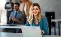 Successful young attractive businesswoman working on laptop in her workstation at office Royalty Free Stock Photo