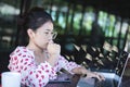 Successful young beautiful southeast asian woman using laptop create online business make money dollar cash falling.money rain Royalty Free Stock Photo